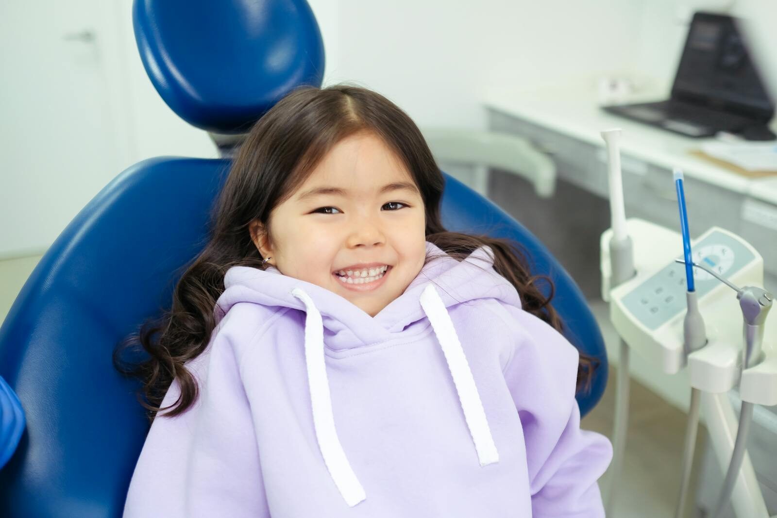 Cheerful child in a dental chair, ready for a dental checkup in a modern clinic.