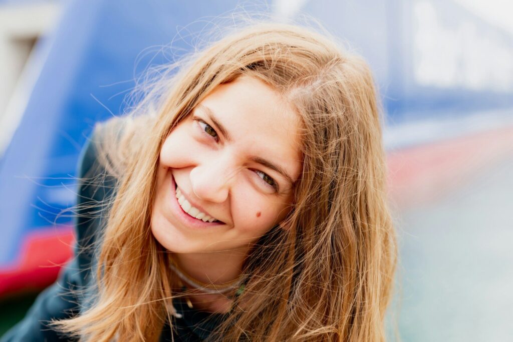 a woman with long blonde hair smiling at the camera